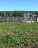 Деревянный дом на ровном плодородном земельном участке в пределах населенного пункта